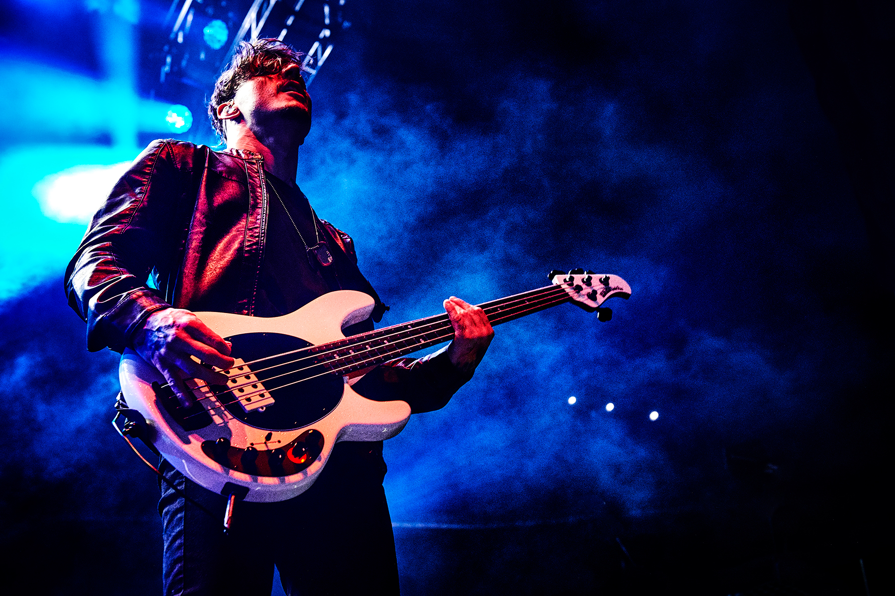 Rotten Bobby playing bass under blue stage lights